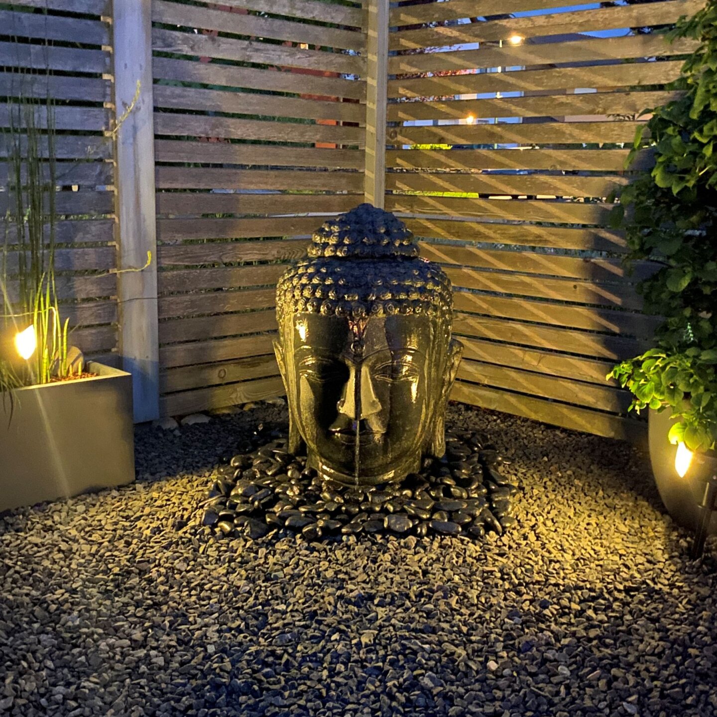 Buddha-Kopf als Wasserspiel im Garten