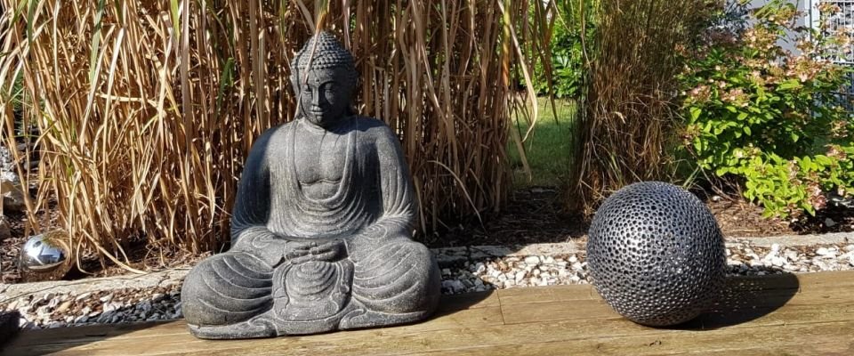 steinfigur buddha im garten auf terrasse